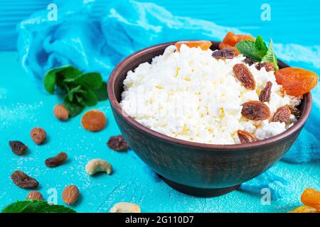 Gesundes Frühstück Hüttenkäse mit Rosinen, getrockneten Aprikosen, Mandel, Cashew und Minze Stockfoto