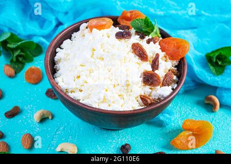 Gesundes Frühstück Hüttenkäse mit Rosinen, getrockneten Aprikosen, Mandel, Cashew und Minze Stockfoto