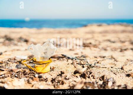 Nahaufnahme einer zerbrochenen Plastikflasche am Strand - Konzept der Meeresverschmutzung und des Klimawandels durch menschliche Verantwortung - verschwommener Hintergrund Stockfoto