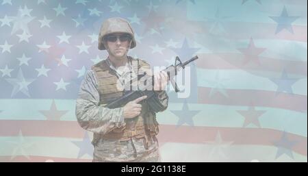 Zusammensetzung eines männlichen Soldaten, der Maschinengewehr über der amerikanischen Flagge hält Stockfoto