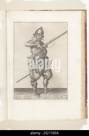 Soldat auf der Wache, dass der Docht auf dem Hahn seines Steuerruders den richtigen Platz und die richtige Form gibt (Nr. 41), ca. 1600. Ein Soldat wartet, in voller Länge, auf der rechten Seite, das ist ein Aufsehen (eine bestimmte Art von Schusswaffe) mit seiner linken Hand hält (no 41), ca. 1600. Mit einem Daumen und Mittelfinger seiner rechten Hand gibt er dem brennenden Docht auf dem Hahn (Teil des Entzündungsmechanismus) seines Rührers den richtigen Platz und die richtige Form. Es handelt sich also um die gleiche Position wie auf dem achten Druck der Serie. Platte 41 in der Anleitung zum Umgang mit dem Helm. Teil der Illustrationen in: J. de Ghey Stockfoto