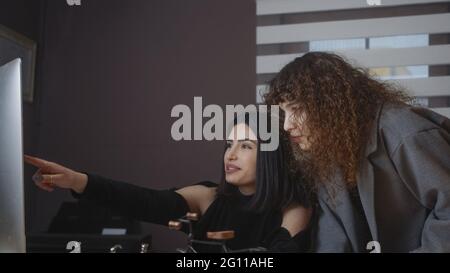 Eine Geschäftsfrau hört sich in ihrem Büro einen professionellen Berater an, sie diskutiert über die Datenvorstellung am Computer. Stockfoto