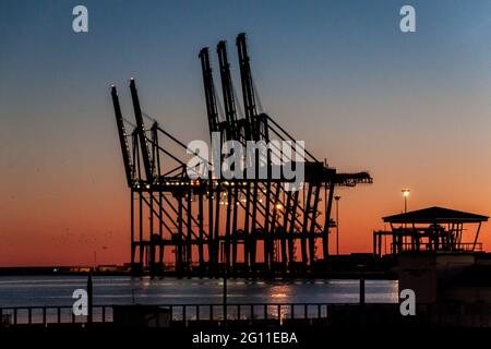 Abendansicht von Kränen in einem Hafen in Malaga, Spanien Stockfoto