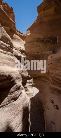 Verschiedene Felsformationen im Red Canyon, in der Nähe von Eilat, Israel, an einem klaren, sonnigen Tag. Metallgriffe ermöglichen es, in den Canyon vorzudringen. Stockfoto