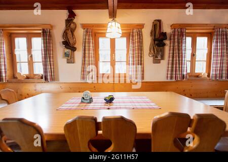 Mittenwald, Deutschland. Juni 2021. Ein leerer Tisch ist in einem Speisesaal der Mittenwalder Hütte zu sehen. Die Schutzhütte nordwestlich unterhalb der westlichen Karwendelspitze auf 1518 Metern Seehöhe ist eine Alpenvereinshütte der Sektion Mittenwald des Deutschen Alpenvereins (DAV). (To dpa-Korr 'Strenge Corona-Regeln: Alpenverein fürchtet schwierige Hüttensaison' von 04.06.2021) Quelle: Matthias Balk/dpa/Alamy Live News Stockfoto