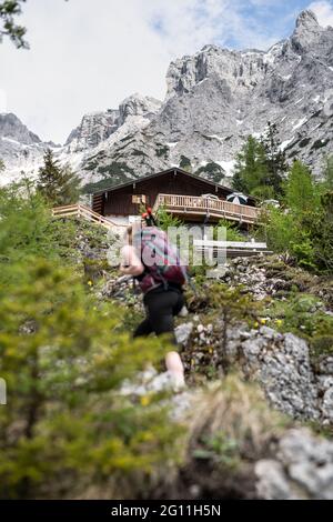 Mittenwald, Deutschland. Juni 2021. Hinter der Mittenwalder Hütte ist das Karwendelmassiv zu sehen. Die Schutzhütte nordwestlich unterhalb der westlichen Karwendelspitze auf 1518 Metern Seehöhe ist eine Alpenvereinshütte der Sektion Mittenwald des Deutschen Alpenvereins (DAV). (To dpa-Korr 'Strenge Corona-Regeln: Alpenverein fürchtet schwierige Hüttensaison' von 04.06.2021) Quelle: Matthias Balk/dpa/Alamy Live News Stockfoto