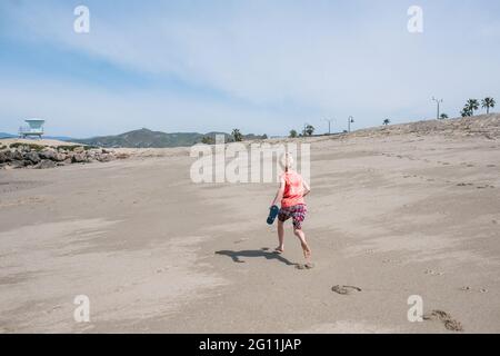 USA, Kalifornien, Ventura, Rückansicht des Jungen, der am Strand läuft Stockfoto