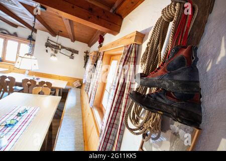 Mittenwald, Deutschland. Juni 2021. Kletterausrüstung mit Seil und Kletterschuhen kann als Dekoration in einem Speisesaal der Mittenwalder Hütte gesehen werden. Die Schutzhütte nordwestlich unterhalb der westlichen Karwendelspitze auf 1518 Metern Seehöhe ist eine Alpenvereinshütte der Sektion Mittenwald des Deutschen Alpenvereins (DAV). (To dpa-Korr 'Strenge Corona-Regeln: Alpenverein fürchtet schwierige Hüttensaison' von 04.06.2021) Quelle: Matthias Balk/dpa/Alamy Live News Stockfoto