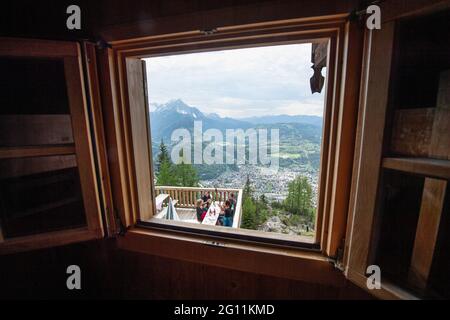 Mittenwald, Deutschland. Juni 2021. Bergsteigerinnen werden durch ein Fenster auf der Terrasse der Mittenwalder Hütte vor dem Panorama der Bayerischen Alpen gesehen. Die Schutzhütte nordwestlich unterhalb der westlichen Karwendelspitze auf 1518 Metern Seehöhe ist eine Alpenvereinshütte der Sektion Mittenwald des Deutschen Alpenvereins (DAV). (To dpa-Korr 'Strenge Corona-Regeln: Alpenverein fürchtet schwierige Hüttensaison' von 04.06.2021) Quelle: Matthias Balk/dpa/Alamy Live News Stockfoto