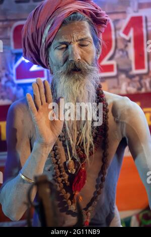 Haridwar, Uttarakhand, Indien 12. April 2021. Indische Heilige in ihrer traditionellen Art von Yog Mudra, meditierend. Schweigend sitzen als Teil der Initiation von neuem Sadhus während Kumbha Mela. Die Naga Sadhus. Stockfoto