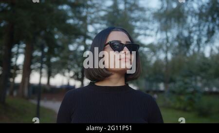 Kurze Haare schöne junge Frau geht die Straße entlang mit Sonnenbrillen Stockfoto