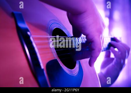 GitarreEin Mann in einem karierten Cowboy-Shirt spielt Country-Musik auf einer westlichen Dreadnought-Gitarre Stockfoto