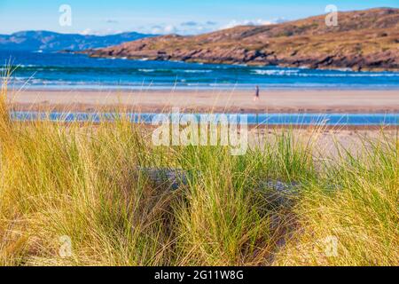 Sanddünen und eine Einzelfigur am Achnahaird-Strand auf der Halbinsel Assynt im Nordwesten Schottlands Stockfoto