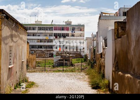 Das arme Viertel, in dem typische Architektur auf vernachlässigte Wohnblöcke trifft, in Olhao, Algarve, Portugal Stockfoto