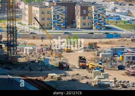 Baustelle eines mehrstöckigen Gebäudes mit Materialien und Sonderausstattung. Blick von oben. Tscheljabinsk, Russland, 17. Mai 2021 Stockfoto