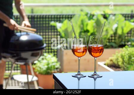Zwei sommerliche apperitive Drinks (venezianischer Spritz, aperol) auf einem Tisch im Balkongarten Stockfoto