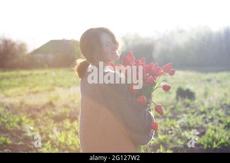 Mädchen mit einem riesigen Strauß roter Tulpen Stockfoto