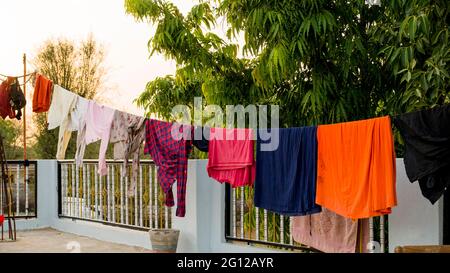 Auf dem Dach, Seil mit sauberer Kleidung im Freien am Waschtag. Bunte Kleidung in Wäscheleine hängen. Stockfoto