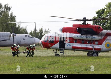 HAI, UKRAINE - 4. JUNI 2021 - Rettungskräfte bringen eine „verletzte“ Person zu einem Hubschrauber während der Spezialübungen des ukrainischen Staatlichen Notdienstes auf dem Trainingsgelände des Interregionalen Krisenreaktionszentrums, Dorf Hai, Region Sumy, im Nordosten der Ukraine. Kredit: Ukrinform/Alamy Live Nachrichten Stockfoto