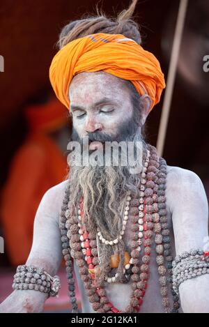 Haridwar, Uttarakhand, Indien 12. April 2021. Indische Heilige in ihrer traditionellen Art von Yog Mudra, meditierend. Schweigend sitzen als Teil der Initiation von neuem Sadhus während Kumbha Mela. Die Naga Sadhus. Stockfoto