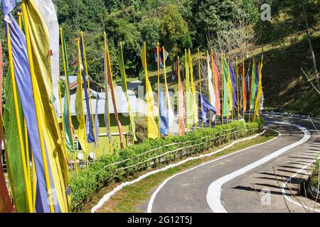 Schöner Weg zum Kloster von Rhong in Rhong, farbenprächtiges Buddistengebet, religiöse Fahnen winken am Straßenrand. Ralong ist voll von landschaftlich schönen natürlichen vi Stockfoto