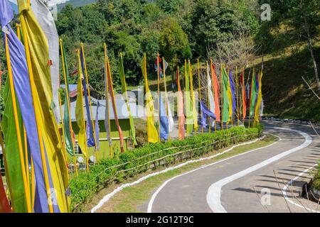 Schöner Weg zum Kloster von Rhong in Rhong, farbenprächtiges Buddistengebet, religiöse Fahnen winken am Straßenrand. Ralong ist voll von landschaftlich schönen natürlichen vi Stockfoto