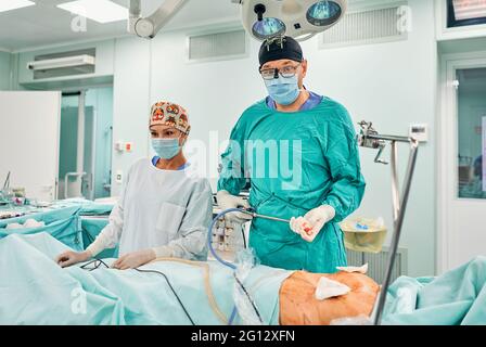 Gutaussehende Neurochirurgie harte Arbeit im professionellen Krankenhaus. Männlicher Chirurg, der im Operationsraum arbeitet. Stockfoto