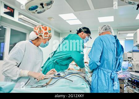 Gutaussehende Neurochirurgie harte Arbeit im professionellen Krankenhaus. Männlicher Chirurg, der im Operationsraum arbeitet. Stockfoto