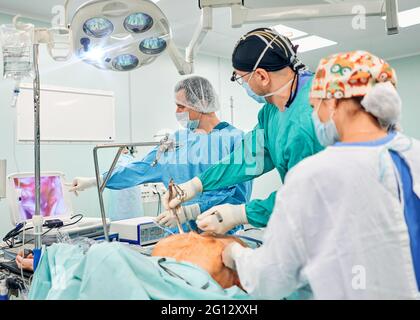 Gutaussehende Neurochirurgie harte Arbeit im professionellen Krankenhaus. Männlicher Chirurg, der im Operationsraum arbeitet. Stockfoto