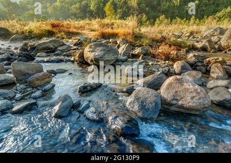 Wunderschönes Reshi-Flusswasser, das in der Morgendämmerung auf Felsen fließt, Sikkim, Indien - eine spektakuläre Aussicht, getöntes Bild Stockfoto