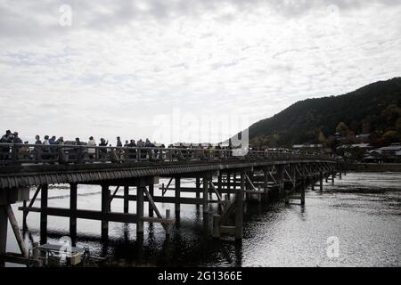 KYOTO, JAPAN - Dec 11, 2019: Kyoto, Japan-26 Nov, 2019: Togetsu-kyo Brücke über Katsuragawa Fluss mit buntem Waldberg Hintergrund in Arashiy Stockfoto