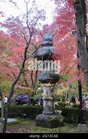 KYOTO, JAPAN - 13. Dez 2019: Kyoto, Japan- 24. Nov 2019: Portrait einer typischen japanischen Steinlaterne am Eikando Tempel in Kyoto, mit Rot und yel Stockfoto