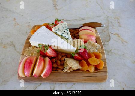 Käseplatte mit frischem Obst und Nüssen Stockfoto