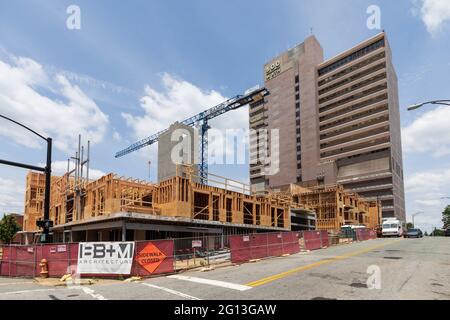 WINSTON-SALEM, NC, USA-1. JUNI 2021: Neubau mit einem Kran auf dem Gelände in der 5th Street und Poplar Downtown sowie das Bürohochhaus mit dem Namen 500 Stockfoto