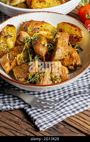 Appetitliches Eintopf aus Schweinefilet, im Wok gegarten, in Würfel geschnitten. Mit gerösteten und goldenen Kartoffeln, Knoblauch, Salz, Orangano und frischen Tomaten. Stockfoto