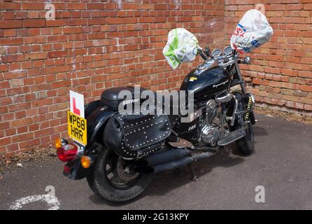 Geparktes Motorrad mit Einkaufstasche-Handgriffen Stockfoto