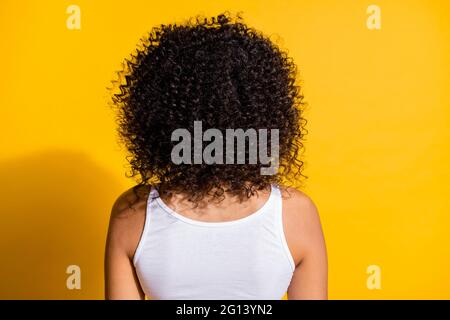 Hinten Porträt der dunklen Haut Mädchen haben schöne Haare Locken tragen Tank-Top isoliert auf lebendige gelbe Farbe Hintergrund Stockfoto