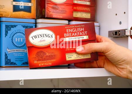 Tambow, Russische Föderation - 25. Januar, 2021 Person Hand nehmen Twinings Teebox aus dem Schrank Regal. Stockfoto