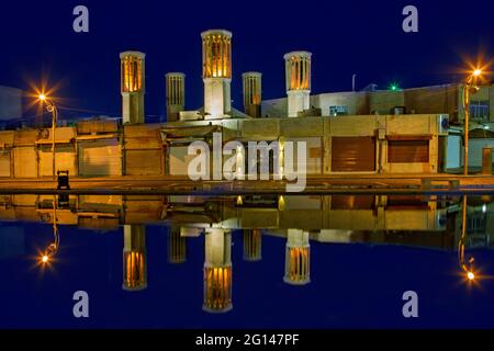 Windtürme und Spiegelungen im Teich, in der Dämmerung, in der antiken Stadt Yazd, Iran Stockfoto