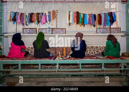 Iranische Frauen weben persische Teppiche in der Teppichwerkstatt in Naein, Iran. Stockfoto