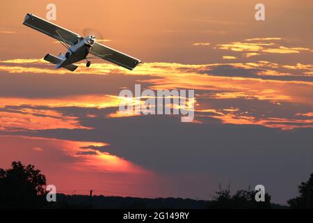 Privates Einzelpropeller-Flugzeug gegen den dramatischen Himmel - digitale Komposition. Stockfoto