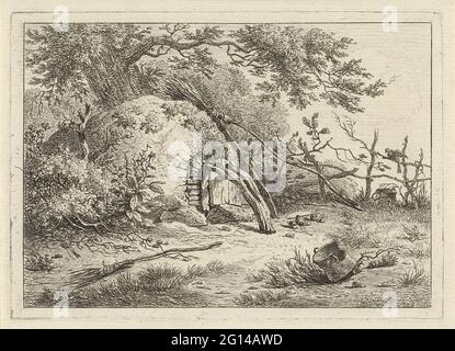 Backofen mit Besen. Das Gesicht auf dem halbrunden Ofen beim Baum. Ein Besen ist gegen den Ofen, ein zweiter Besen liegt auf dem Boden. Die Tür des Backofens ist mit einem gebogenen Baumstamm verschlossen. Stockfoto