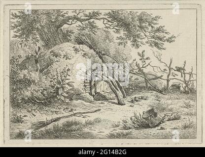 Backofen mit Besen. Das Gesicht auf dem halbrunden Ofen beim Baum. Ein Besen ist gegen den Ofen, ein zweiter Besen liegt auf dem Boden. Die Tür des Backofens ist mit einem gebogenen Baumstamm verschlossen. Stockfoto