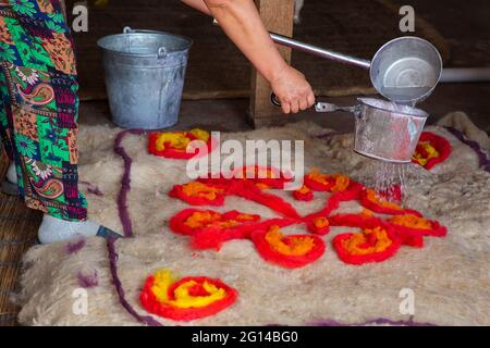 Es fühlte sich traditionell an, indem man heißes Wasser auf den Filzteppich setzte. Stockfoto