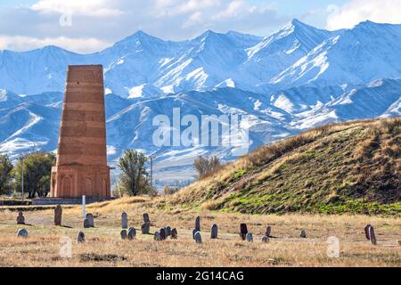 Burana Turm, ein historisches Minarett in den Ruinen der antiken Stätte von Balasagun mit Grabsteinen, die als Balbas im Vordergrund, Kirgisistan, bekannt sind Stockfoto