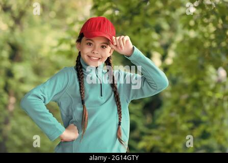 Hipster Baby. Happy Hipster tragen Snapback natürlich im Freien. Kleines Kinderlächeln im Hipster-Stil. Hip-Hop-Mädchen. Flippige Schönheit. Modisch cool. Kinder Stockfoto