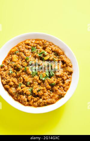 Nahaufnahme des Keema-Crüms in der Schüssel auf gelbem Hintergrund. Indische und pakistanische Gerichte. Stockfoto