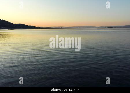 GOLUBAC, SERBIEN - 11. AUGUST 2019: Atemberaubende Sonnenuntergangslandschaft der Küstenstraße und der Donau in der Stadt Golubac, Serbien Stockfoto