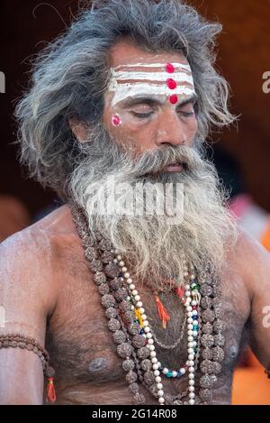 Haridwar, Uttarakhand, Indien 12. April 2021. Indische Heilige in ihrer traditionellen Art von Yog Mudra, meditierend. Schweigend sitzen als Teil der Initiation von neuem Sadhus während Kumbha Mela. Die Naga Sadhus. Stockfoto