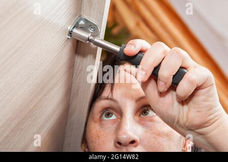 Selbstmontage von Möbeln aus flacher Verpackung, Frau festzieht Befestigungsmutter. Stockfoto